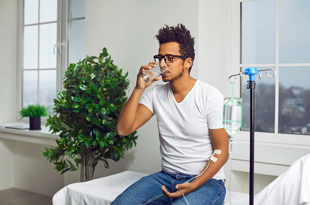 Younger_Gentleman_Drinking_Water_While_Receiving_IV