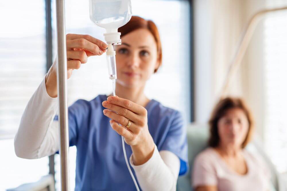 a nurse with iv drip and patient in bed in hospita 2023 11 27 05 20 48 utc